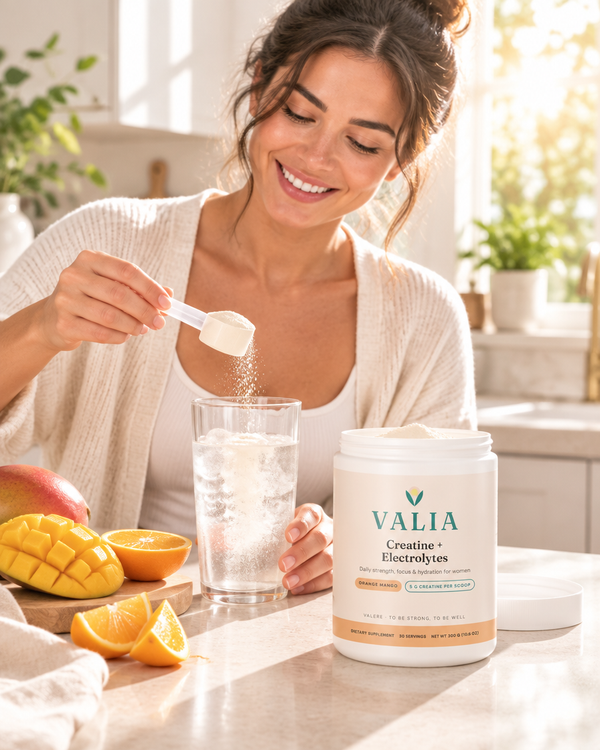 Woman making VALIA Orange Mango in a sunny kitchen